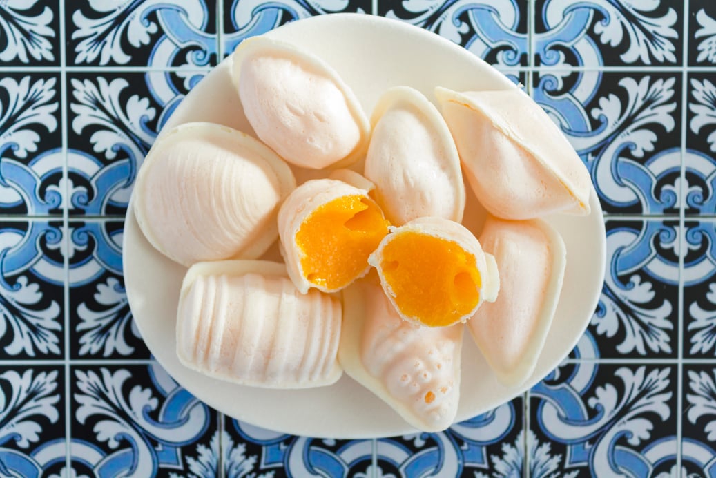 Top view of traditional portuguese egg yolk sweets called Ovos Moles de Aveiro on portuguese tiles background